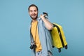 Cheerful traveler tourist man in yellow summer casual clothes with photo camera isolated on blue background. Male