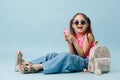 Cheerful tween girl in pink shirt and round sunglasses using her phone Royalty Free Stock Photo