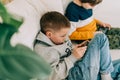 Cheerful two Childs boys playing online game, watching video on cellphone. Smiling kids using funny mobile apps Royalty Free Stock Photo