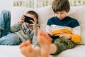 Cheerful two Childs boys playing online game, watching video on cellphone. Smiling kids using funny mobile apps Royalty Free Stock Photo