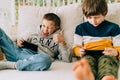 Cheerful two Childs boys playing online game, watching video on cellphone. Smiling kids using funny mobile apps Royalty Free Stock Photo