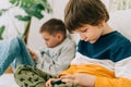 Cheerful two Childs boys playing online game, watching video on cellphone. Smiling kids using funny mobile apps Royalty Free Stock Photo