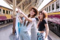 Traveler young woman standing in the train station. Joyful tourist girl wear hat holding map in her hand, pointing
