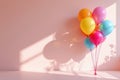 A cluster of brightly colored balloons casts soft shadows on the pink wall. Royalty Free Stock Photo