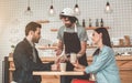 Cheerful waiter serving cakes and coffee to couple Royalty Free Stock Photo