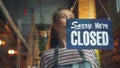 Cheerful waitress changing closed to open sign smiling waiting for customers