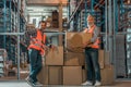 cheerful warehouse workers standing with boxes and smiling Royalty Free Stock Photo