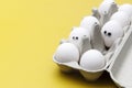 cheerful white eggs with glasses in a box with ordinary eggs. Creative image. Easter concept