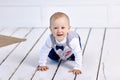 Cheerful white toddler crawls on floor in lounge. Royalty Free Stock Photo