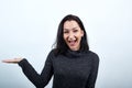 Cheerful woman in black sweater pointing hand aside, looking at camera Royalty Free Stock Photo