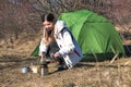 Cheerful woman camping alone cooking in front of her tent Royalty Free Stock Photo