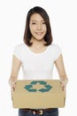 Cheerful woman carrying a recyclable cardboard box