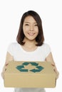 Cheerful woman carrying a recyclable cardboard box