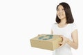 Cheerful woman carrying a recyclable cardboard box