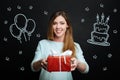 Cheerful woman coming to a party and bringing a big present Royalty Free Stock Photo