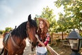 Cheerful woman cowgirl standing with her horse in village Royalty Free Stock Photo