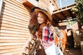 Cheerful woman cowgirl standing and hugging her horse on farm Royalty Free Stock Photo