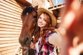 Cheerful woman cowgirl standing taking selfie with horse on farm Royalty Free Stock Photo