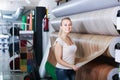 cheerful woman customer choosing linoleum flooring in hypermarket Royalty Free Stock Photo
