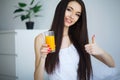 Cheerful woman drinking an orange juice sitting on her bed Royalty Free Stock Photo