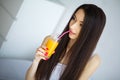 Cheerful woman drinking an orange juice sitting on her bed at ho Royalty Free Stock Photo