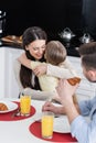 cheerful woman embracing daughter near blurred Royalty Free Stock Photo