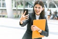 Cheerful woman employee using video call contact with friend in the city