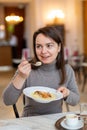 Cheerful woman enjoying apple strudel with espresso in coffee house Royalty Free Stock Photo