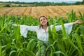 Cheerful woman farmer posing in the corn crop. Young happy girl showing harvested corn in the field. Royalty Free Stock Photo