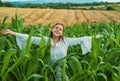 Cheerful woman farmer posing in the corn crop. Young happy girl showing harvested corn in the field. Royalty Free Stock Photo