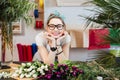 Cheerful woman florist selling tulips in flower shop