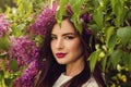 Cheerful woman in flowers outdoors. Young perfect female model in blossom garden Royalty Free Stock Photo