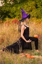 Cheerful woman in witch costume practicing yoga