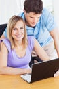 Cheerful woman and her boyfriend using a laptop