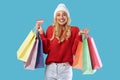 Cheerful woman holding credit card carrying shopping bags in winter Royalty Free Stock Photo