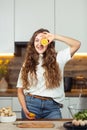 Healthy lifestyle concept, beautiful smiling woman Holding Fresh Lemon Slice In Front of her One Eye While Looking at Royalty Free Stock Photo