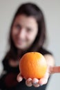 Cheerful woman holding orange