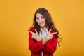 Cheerful woman keeping hands crossed, pointing fingers aside, looking at camera, Royalty Free Stock Photo
