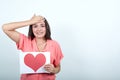 Cheerful woman keeping whine paper with shape of heart, holding hand on head Royalty Free Stock Photo