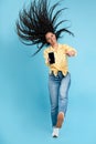 Cheerful lady jumping and pointing at empty smart phone screen