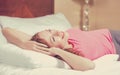 Cheerful woman lying on the bed at home daydreaming resting. Royalty Free Stock Photo