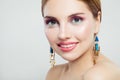 Cheerful woman with makeup and gold earrings, cute female face closeup portrait Royalty Free Stock Photo