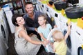 Cheerful woman and man with children shopping washer