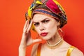 cheerful woman in multicolored turban attractive look Jewelry red background Royalty Free Stock Photo