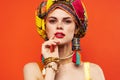 cheerful woman in multicolored turban attractive look Jewelry red background Royalty Free Stock Photo