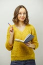 Cheerful woman with an open notebook in her hands and raised handle to the top, expresses joy and jubilation