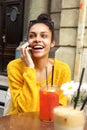 Cheerful woman at outdoor cafe using mobile phone Royalty Free Stock Photo