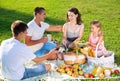 Cheerful woman picnicking with children and husband