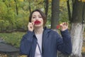 Cheerful woman with a red leaf as lips