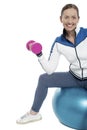 Cheerful woman seated on pilates ball and exercising Royalty Free Stock Photo